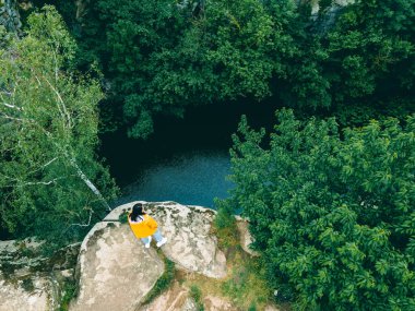 Kadın tepede oturuyor Kanyon nehri ormanının manzarasının tadını çıkarıyor
