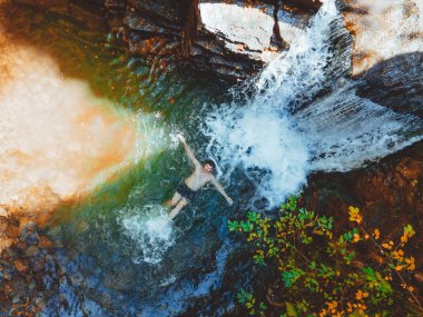 Sonbahar şelalesinde yüzen insan manzarası