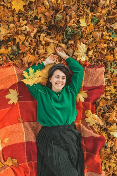 秋天的公园里 一个女人躺在地上的毯子上 梦想着什么 — 图库照片