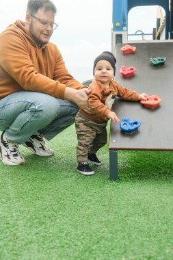 Baba Çocuk 'a Çocuk Bahçesinde Yardım Ediyor Duvara Tırmanma.