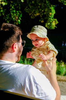 Baba ve Bebek Parkta Güneşli bir günün tadını çıkarıyorlar.