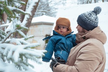 Baba ve çocuk karlı bir kış gününün tadını çıkarıyorlar.
