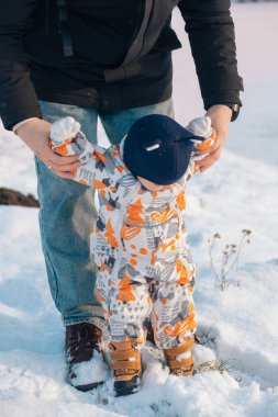 Kar Elbiseli Bebek Karlı Manzarada Yetişkin Tarafından Tutuldu.