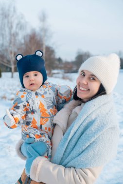 Gülümseyen anne ve bebek Kış gününün tadını çıkarıyorlar