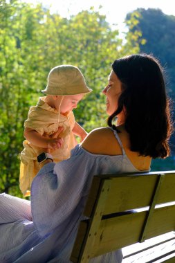 Anne ve Çocuk Parkta Güneşli bir günün tadını çıkarıyor.