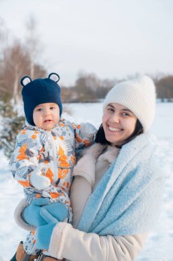 Gülümseyen anne ve bebek Kış gününün tadını çıkarıyorlar