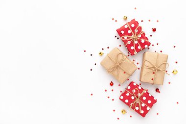 Kırmızı noktalı Noel hediyeleri, takılar, kırmızı ve altın yıldızlı konfetiler. Kopyalama alanı olan yeni yıl arkaplanı.