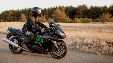 Orman yolu boyunca motosikletle gezerler. Spor motosikletinde boş bir yolda iyi eğlenceler. Özelleştirilmiş metnin için alanı kopyala