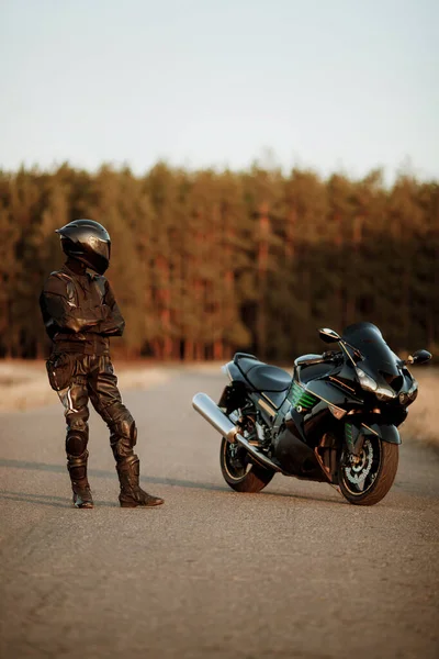 Kierowca Motocykla Kasku Skórzanej Kurtce Stoi Drodze Zachodzie Słońca Pięknym — Zdjęcie stockowe