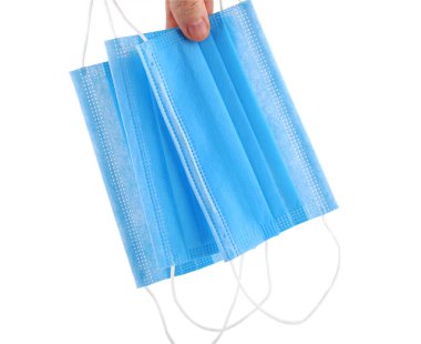 Beyaz izole edilmiş arka planda mavi tıbbi tek kullanımlık yüz maskesi. Kulak kepçeli tek kullanımlık nefes filtresi maskesi