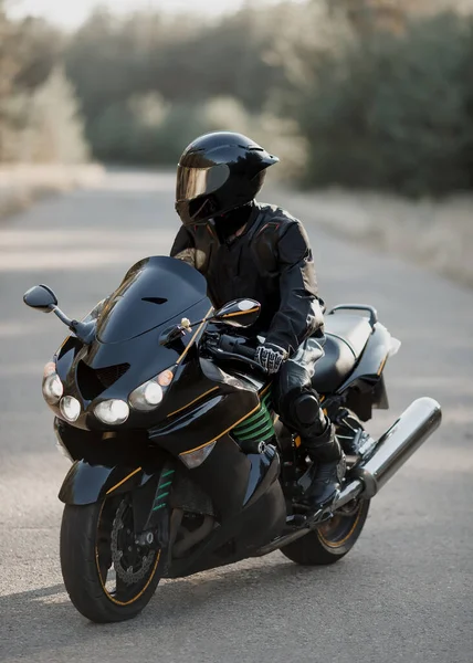 Schwarzer Motorradfahrer Mit Helm Auf Straße Mit Verschwommenem Hintergrund — Stockfoto
