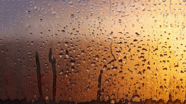 Yatay doğal arkaplan, pencereye güneş ışınlarıyla su damlaları damlayan damlalarla camda yoğunlaşma.