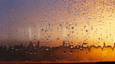 Terli cam pencerede yoğunlaşan damlalar. Soğuk sisli cam. Islak pencere arkaplanı, damlayan damlalarla birlikte doku yoğunlaşması