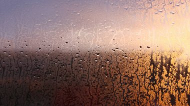 Yatay doğal arkaplan, pencereye güneş ışınlarıyla su damlaları damlayan damlalarla camda yoğunlaşma.