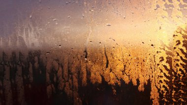 Yoğunlaşmanın doğal arkaplanı, pencere camında akan su damlaları