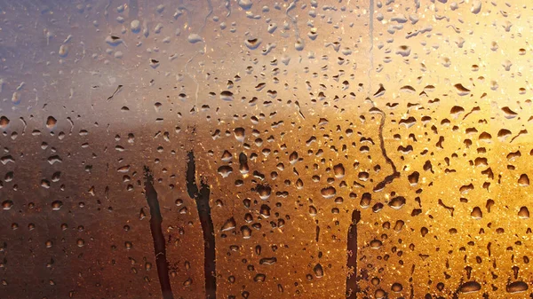 Drops condensation on the clear glass window. Water drops. Abstract background texture, condensation on the glass with dripping drops