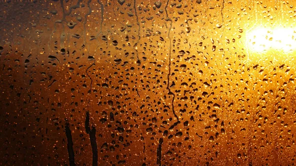 Drops condensation on the clear glass window. Water drops. Abstract background texture, condensation on the glass with dripping drops