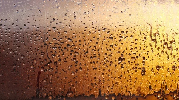 Drops condensation on the clear glass window. Water drops. Abstract background texture, condensation on the glass with dripping drops