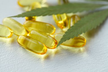 Tıbbi esrar ürünleri, yaprak, kapsüller ve beyaz arka planda CBD yağı. Biyolojik bitkisel bitkilerle birlikte jelatin softgeller. Organik beslenme takviyeleri