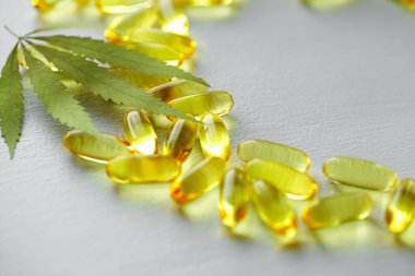 CBD yağ kapsülleri ve kenevir yaprakları. Biyolojik ve ekolojik kenevir bitkisinin kapsüllerini kapatın bitkisel eczacılık cbd yağı