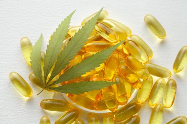 CBD yağ kapsülleri ve kenevir yaprakları. Biyolojik ve ekolojik kenevir bitkisinin kapsüllerini kapatın bitkisel eczacılık cbd yağı