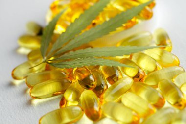 CBD yağ kapsülleri ve kenevir yaprakları. Biyolojik ve ekolojik kenevir bitkisinin kapsüllerini kapatın bitkisel eczacılık cbd yağı