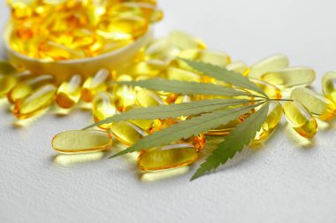 CBD yağ kapsülleri ve kenevir yaprakları. Biyolojik ve ekolojik kenevir bitkisinin kapsüllerini kapatın bitkisel eczacılık cbd yağı