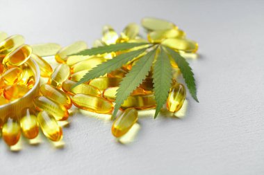 CBD yağ kapsülleri ve kenevir yaprakları. Biyolojik ve ekolojik kenevir bitkisinin kapsüllerini kapatın bitkisel eczacılık cbd yağı