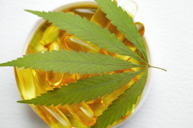 CBD yağ kapsülleri ve kenevir yaprakları. Biyolojik ve ekolojik kenevir bitkisinin kapsüllerini kapatın bitkisel eczacılık cbd yağı