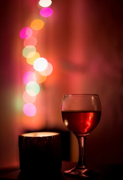 Glas Rotwein und Kerze Stockfoto