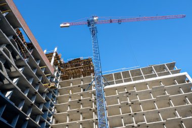 Mavi gökyüzü arka plan üzerinde inşaat vinçleri