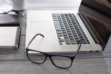 Bilgisayar gözlük ve masanın üstüne telefon
