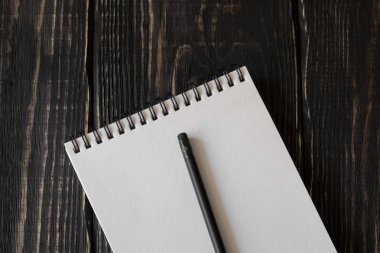 Beyaz defter ve kalem ahşap arka plan üzerinde