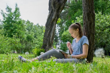Çimenlerin üzerinde oturan kadın çizer