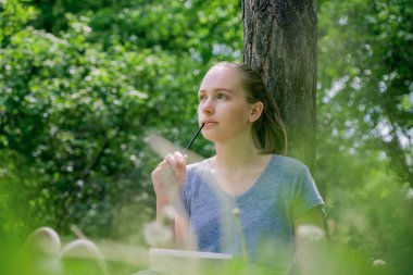 Çimenlerin üzerinde oturan kadın çizer