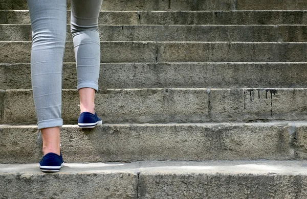 Frauenfüße in Turnschuhen zum Treppensteigen — Stockfoto