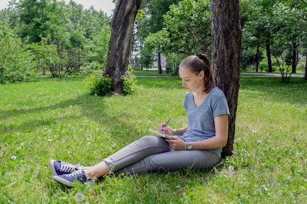 Felhívja a nő ül a fűben — Stock Fotó