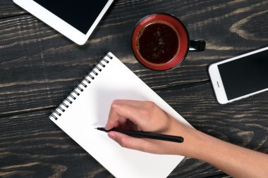 El bir siyah kalem beyaz bir Not Defteri'nde yazıyor.