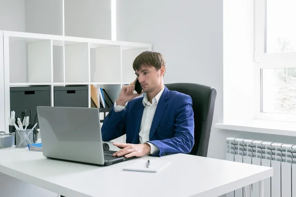 Людина з ноутбуком в офісі — стокове фото