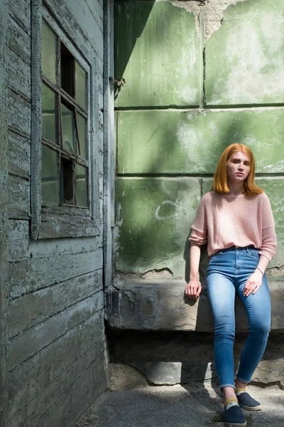 Yeşil duvar yakınındaki Kızıl saçlı kız