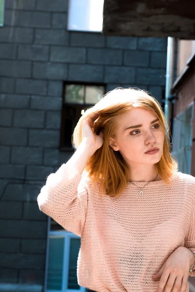 Kızıl saçlı kız sokakta ayakta