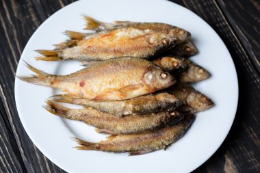 Beyaz tabakta kızarmış balık.