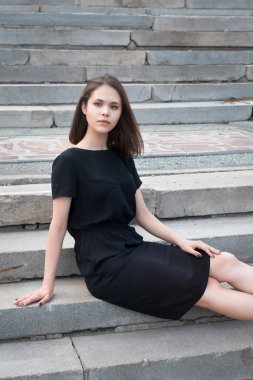 Merdivenlerde oturan kız.