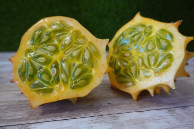 Boynuzlu kavun ikiye bölünmüş, canlı yeşil sulu hamur ve beyaz tohumlar gösteriyor, egzotik sağlıklı yiyecek kavramı sunuyor.