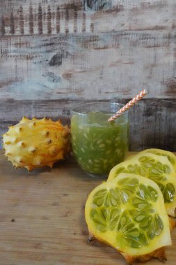 Boynuzlu kavun dilimlenmiş ve ferahlatıcı bir kiwano meyve suyu ile sağlıklı tüketime hazır.
