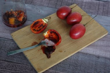 Tamarillo, aynı zamanda ağaç domatesi olarak da bilinir, meyve soyulmuş, sulu hamurlu ve tohumlu, yemeye ya da harmanlamaya hazır.