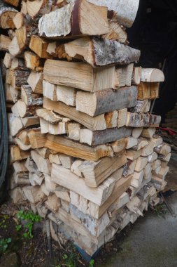 Yığılmış odun kütükleri doğal ahşap dokuları gösteriyor, kış ısıtması için hazırlanıyor. Sıcaklık ve rahatlık için yenilenebilir enerji kaynağı