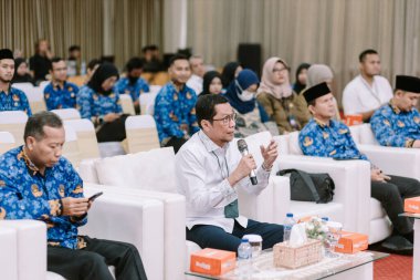 Aralarında tesettürlü bir kadının da bulunduğu 10 Kasım 2025 tarihli Jakarta Panelistleri, Endonezya 'da stratejik bilgilerin gösterildiği geniş bir ekranla profesyonel bir konferansa katıldı..
