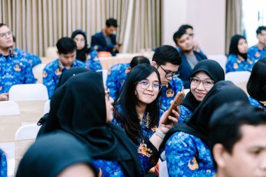 Aralarında tesettürlü bir kadının da bulunduğu 10 Kasım 2025 tarihli Jakarta Panelistleri, Endonezya 'da stratejik bilgilerin gösterildiği geniş bir ekranla profesyonel bir konferansa katıldı..