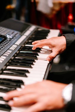 Modern dijital elektronik klavyeyi ustalıkla çalan profesyonel bir müzisyenin ellerine yakından bakmak. Zarif performans müzik yaratma ve canlı eğlence ruhunu yakalar..